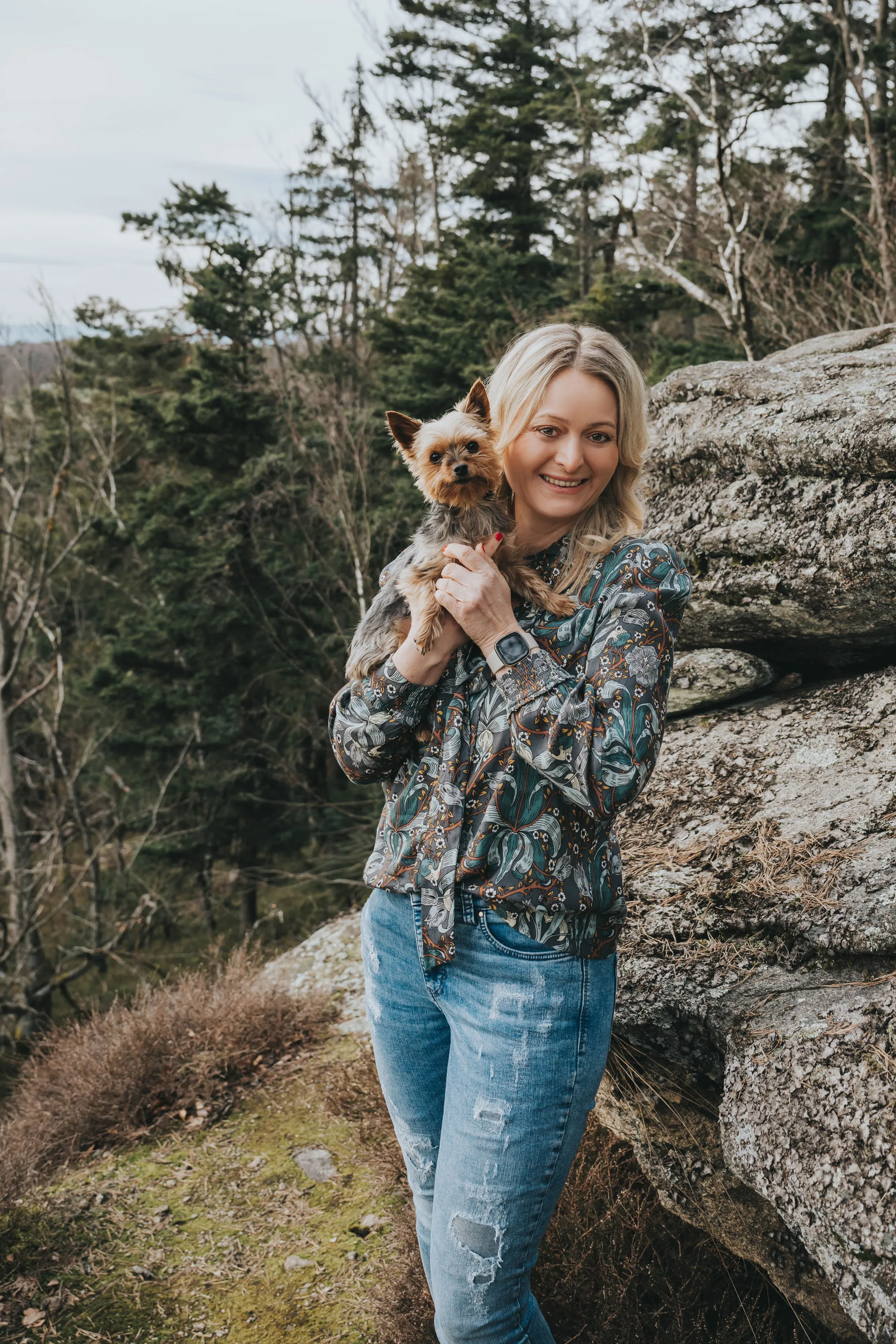 Carmen Dirscherl mit Hund in der Natur vor einem Felsen